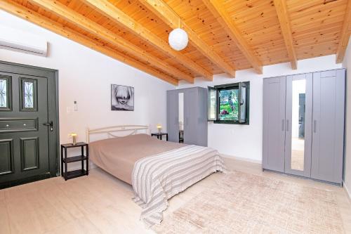a bedroom with a bed and a wooden ceiling at Villa Taxiarchis by Corfuescapes in Benitses
