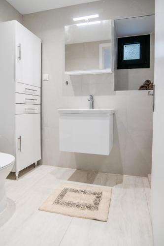 a white bathroom with a tub and a sink at Villa Taxiarchis by Corfuescapes in Benitses