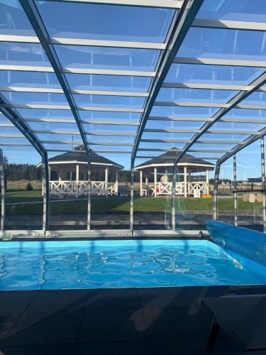 a large swimming pool with a glass roof at Jagodowy Ski&Spa pensjonat z widokiem na góry,podgrzewany basen zewnętrzny latem,bilard,świetne Wi-Fi,Restauracja,balia,sauna na miejscu in Lasowka