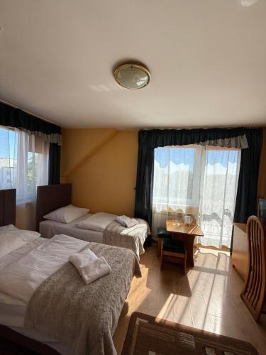 a hotel room with two beds and a table at Hotel Grodzki in Sandomierz