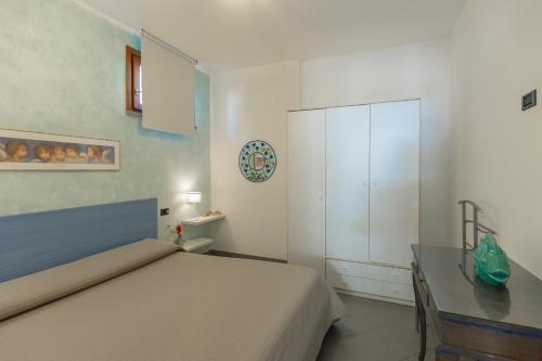 a bedroom with a bed and a desk and a cabinet at Casa Martina by ElbaSummer in Lacona