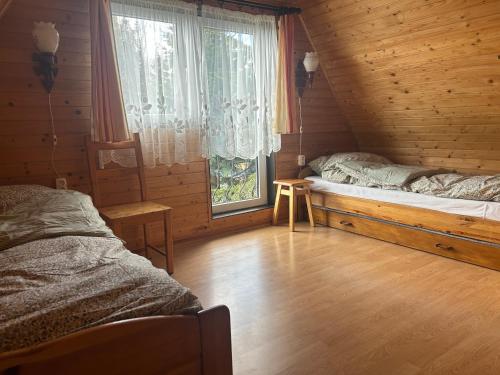 a bedroom with two beds in a wooden cabin at Dom wakacyjny Podlas in Żywiec