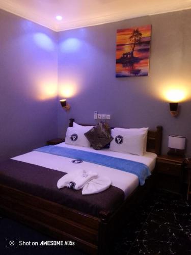 a bedroom with a bed with two towels on it at Trapezium Lodge in Amasaman