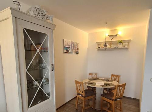 ein Esszimmer mit einem Tisch und einem Schrank in der Unterkunft Ostseemuschel in Damp