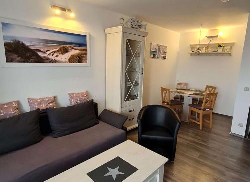ein Wohnzimmer mit Sofa und Esstisch in der Unterkunft Ostseemuschel in Damp