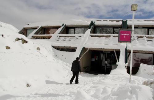 a man standing in the snow in front of a building at Studio 4 pers pieds des pistes Piau-engaly in Aragnouet