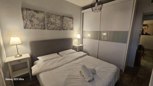 a bedroom with a white bed with two pillows on it at Rona Suite in Caesarea