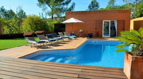 a pool with chairs and a table and an umbrella at Villa Sitges Maria Sunny Oriented SW AC Confortable High Quality 5 star guest coments in Olivella
