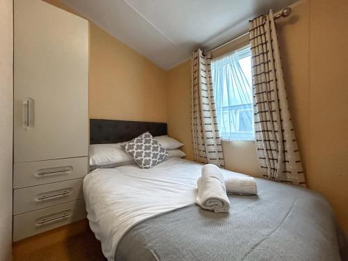 a small bedroom with a bed and a window at The Ash in Angus