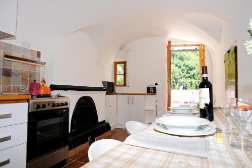 a kitchen with a table and a stove top oven at Panoramic Apartment with Balcony and Terrace in Pigna