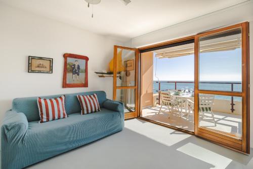 a living room with a couch and a view of the ocean at Fronte mare con parcheggio! in Grado