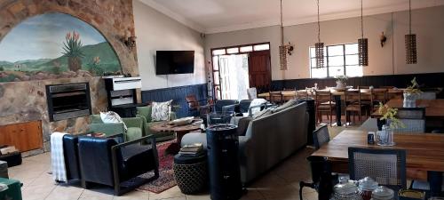 a large room with tables and chairs and a fireplace at Mountain Pastures Game Lodge in Uniondale