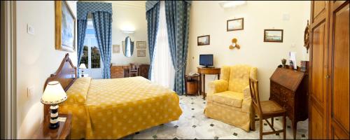 a bedroom with a yellow bed and a chair at Villa Angelina in Massa Lubrense