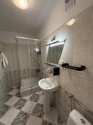 a bathroom with a sink and a shower and a toilet at Hotel Grodzki in Sandomierz
