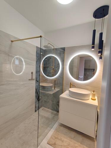 a bathroom with a shower and a mirror at Enidor Wellness Apartman in Siófok