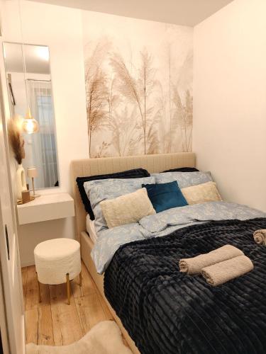 a bedroom with a bed with a black comforter at Enidor Wellness Apartman in Siófok