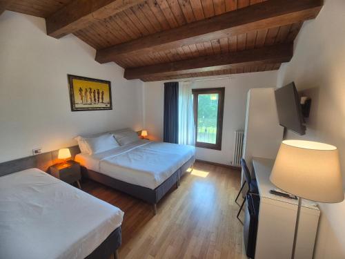 a hotel room with two beds and a television at B&B Bella di Notte in Lugo