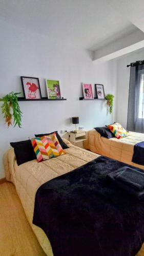 two beds in a room with pictures on the wall at El balcón de Mafalda in Villarcayo
