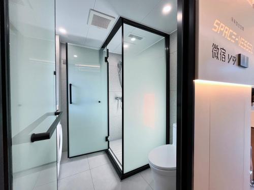 a bathroom with a glass shower and a toilet at space-vessel基地 in Yufu