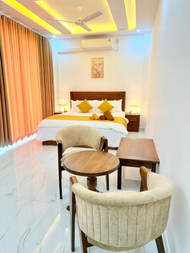 a hotel room with a bed and two chairs and tables at Sky View in Matara