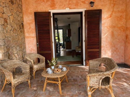 a patio with wicker chairs and a table and a doorway at Villa Pinta - Key to Villas in Codaruina