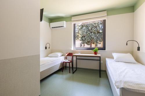 a room with two beds and a sink and a window at Hostel Rest in Krakow