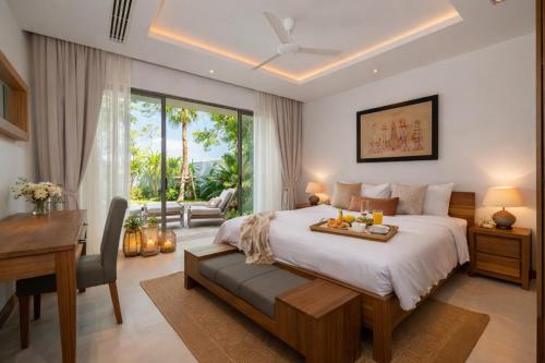 a bedroom with a bed and a desk and a table at Grand garden villa Free Airport Pickup from 7 days in Phuket