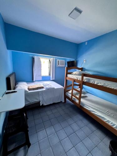 a bedroom with two bunk beds and a blue wall at Pousada Hostel Beach Pajuçara in Maceió