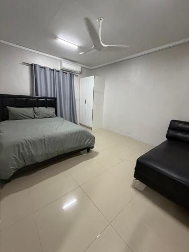 a bedroom with a bed and a couch in it at Doctors Apartment in Suva