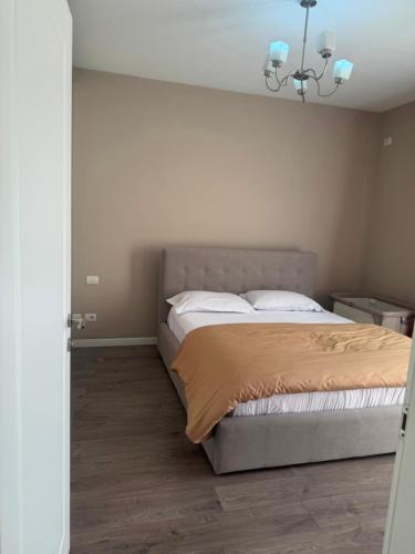 a bedroom with a bed and a chandelier at Valentina Cozy 2-Bedroom House in Lushnjë