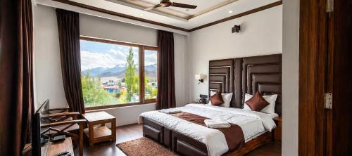 a bedroom with a bed and a large window at Hotel La Park, Leh in Leh