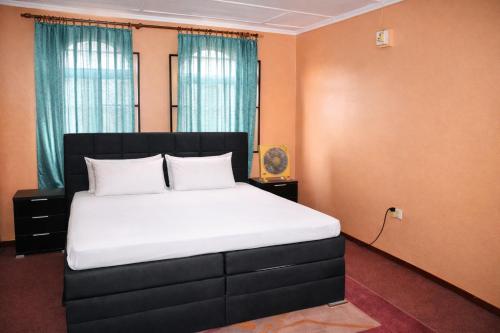 a bedroom with a large bed with white sheets at Rico Home Stay in Nkotunsi