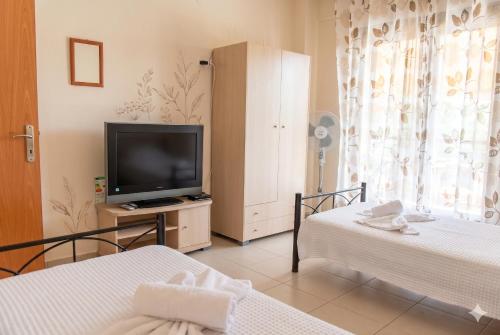 a living room with two beds and a television at Villa Maria in Ierissos