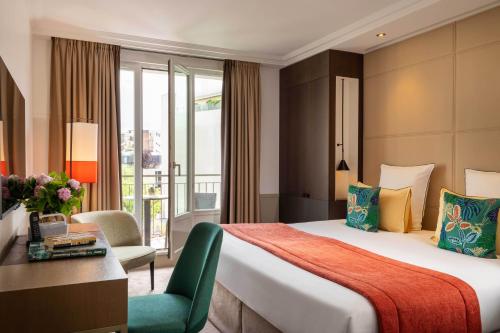 a hotel room with a large bed and a desk at Hotel Villa Saxe Eiffel in Paris