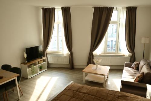 a living room with a couch and two windows at Olive Residence Lübeck in Lübeck