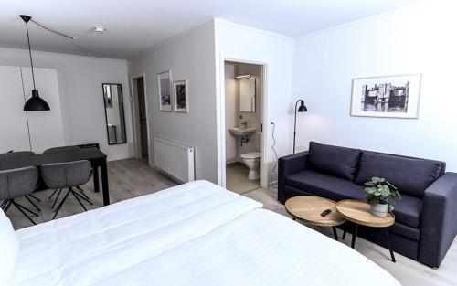 a bedroom with a bed and a couch and a table at Harbour Inn Hundested in Hundested