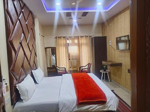 a bedroom with a large bed with a red blanket at Hotel Avadh Balrampur in Balrāmpur