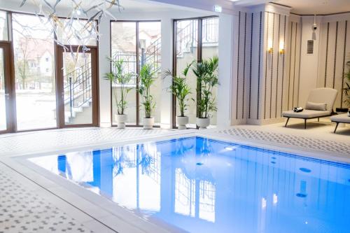 a swimming pool with plants in a building at Dwór Prezydencki Boutique Hotel & SPA in Tarnów
