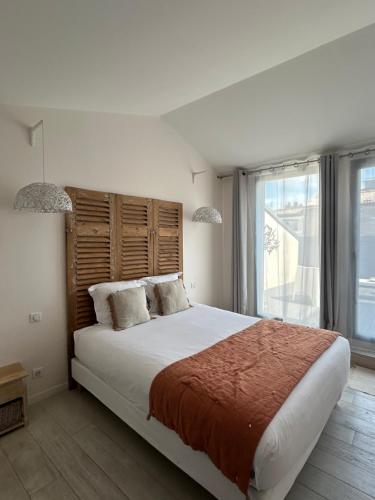 a bedroom with a large bed and a large window at La Maison Odeia Bordeaux Centre in Bordeaux