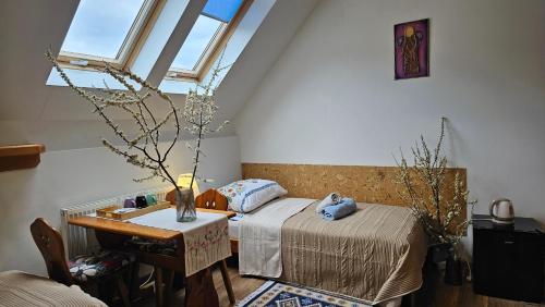 a bedroom with two beds and a table and a window at Oberża Pod Kudłatym Aniołem in Cisna