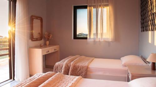 a bedroom with two beds and a window at Ocean Breeze Apartment - Panoramic Sea View & Olive Grove - 100m to Beach in Kypseli