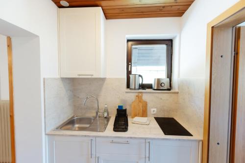 a kitchen counter with a sink and a mirror at House Škantar Bohinj in Bohinj