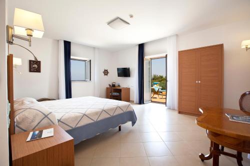a bedroom with a bed and a desk and a table at Villa Angelina in Massa Lubrense
