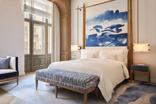 a bedroom with a large white bed with a blue painting at The St. Regis Budapest in Budapest