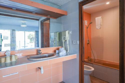 a bathroom with a sink and a toilet at Hotel AMERIQUE in Palavas-les-Flots