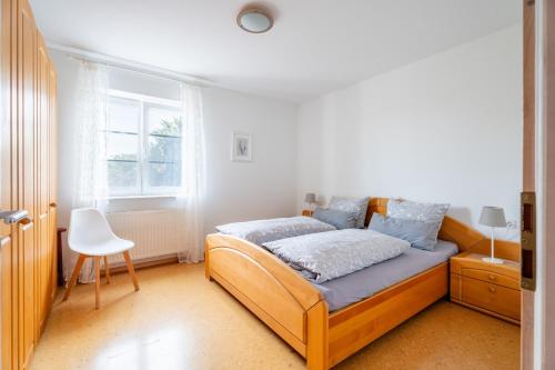 a bedroom with a bed and a chair in it at Ferienwohnung Gartengeschoss in Durbach