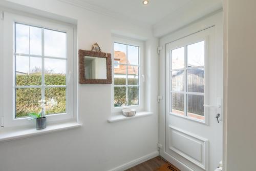a white hallway with two windows and a door at Ant Diekskant in Juist