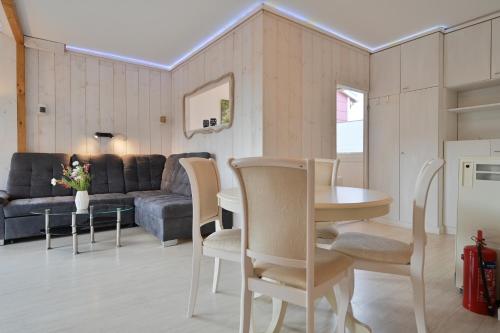 a living room with a couch and a table and chairs at Bungalow Nebel Nr 3 in Kellenhusen