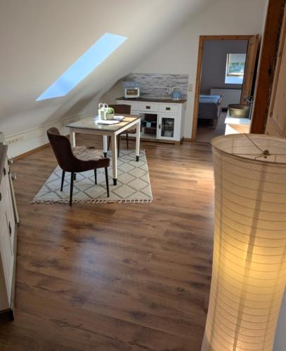 a living room with a table and a chair at Nicht Daheim und doch Zuhaus in Heiligenhafen