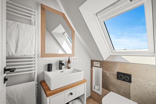 a bathroom with a sink and a window at Traumloft Wenningstedt in Wenningstedt